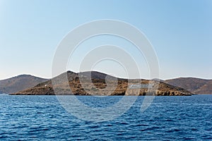 Rocky coastline with a big Greek flag in Kalymnos island, Dodecanese, Greece