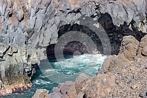 Rocky coastline Los Hervideros in the south west of canary island Lanzarote with rough sea, lava caves and multi colored volcanic