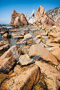 Rocky coastline of Praia Da Ursa beach, Sintra, Portugal. Giant sea stacks towering up from atlantic ocean. Holiday