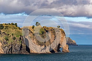 Rocky coastline in Sao Miguel island with characteristic rock formation called Tromba do Elefante Azores, Portugal photo