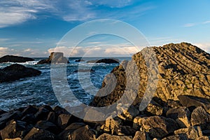 Rocky coastline and sea in dramatic light at sunset