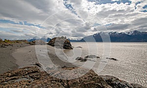 Rocky coastline under blue cloudy sky on Turnagain Arm in Alaska USA