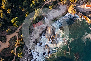 Rocky cove with fishermen`s huts next to a forest