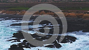 Rocky craggy ocean beach, big sea waves crashing on shore, Monterey 17-mile drive