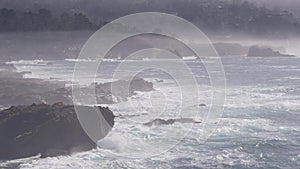 Rocky craggy ocean beach, Point Lobos, foggy California coast. Waves crashing.