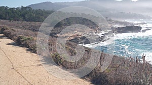 Rocky craggy ocean beach, Point Lobos, foggy California coast. Waves crashing.