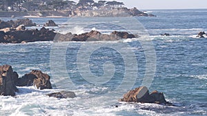 Rocky craggy ocean beach, sea waves crashing on shore, Monterey California coast