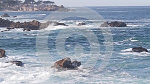 Rocky craggy ocean beach, sea waves crashing on shore, Monterey California coast