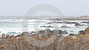 Rocky craggy ocean coast, sea water waves crashing on rocks, Monterey California