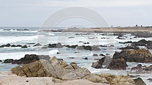 Rocky craggy ocean coast, sea water waves crashing on rocks, Monterey California