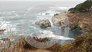 Rocky craggy ocean, foggy weather. Waves crashing on beach. California, Big Sur.