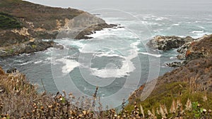 Rocky craggy ocean, foggy weather. Waves crashing on beach. California, Big Sur.