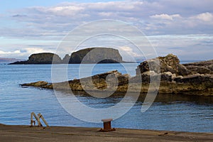 The rocky entrance to the small harbor at Ballintoy on the North Antrim Coast of Northern Ireland on a calm spring day.
