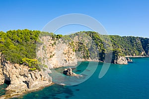 The rocky and green coast, in Europe, in Greece, in Epirus, towards Igoumenitsa, by the Ionian Sea, in summer, on a sunny day