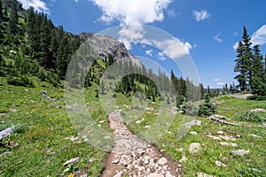 Rocky hiking trail along Blue Lakes in the San Juan Mountains of Colorado during summer