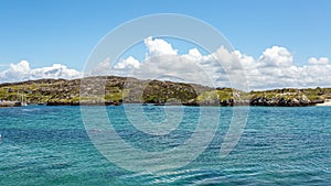 Rocky hills along the coast of Inishbofin Island, calm turquoise water photo