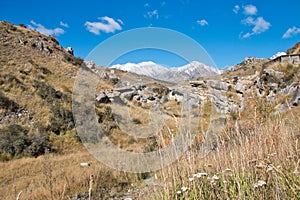 Rocky hillsides and dry meadows afford a glimpse of distant mountains