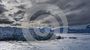 A rocky island in the Beagle Channel is washed by waves.