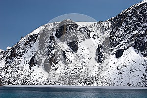 Rocky lake shore covered with snow, Himalayas, Nepal