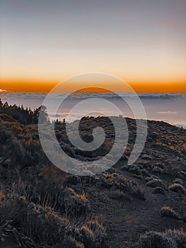 Rocky landscape above the clouds on a sunset