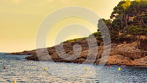 A rocky landscape against the Mediterranean Sea during golden hour