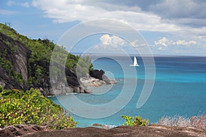 Rocky landscape in the Seychelles with sailing boat on the sea