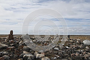 Rocky landscape strewn with tiny Inuksuit along Canada`s arctic coast