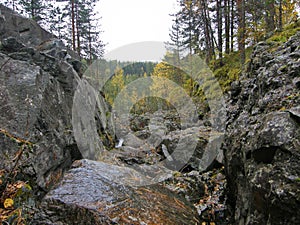 A rocky landscape with trees and rocks in the foreground. Suna River, Poor Porog Waterfall, Girvas, Republic of Karelia, Russia