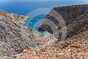 Rocky limestone cliffs of typical Greek or Cretan sea shores, blue or azure sea, clear blue sky and beautiful sky