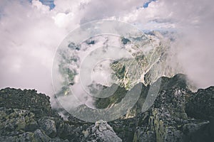 Rocky mountain landscape covered with clouds - vintage film effect