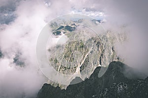 Rocky mountain landscape covered with clouds - vintage film effect