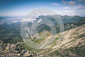 Rocky mountain landscape covered with clouds - vintage film effect