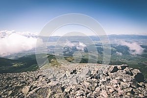 Rocky mountain landscape covered with clouds - vintage film effect