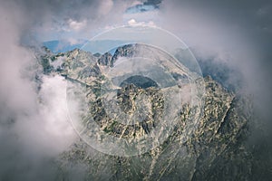 Rocky mountain landscape covered with clouds - vintage film effect