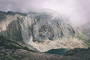 Skalnatá horská krajina pokrytá mrakmi vintage filmový efekt