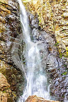 Rocky mountain landscape in Golden colors. Powerful waterfall