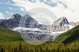 Rocky mountain peaks towering over evergreen forest