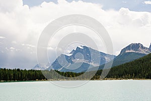 Rocky mountain peaks towering over evergreen forest and lake