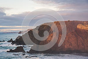 Rocky mountain on the sea under cloudy sky