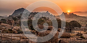 Rocky mountain sunrise flares with dramatic sky at morning flat angle shot is taken at Hemakuta Hill, Hampi, Karnataka india