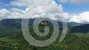 A rocky mountain surrounded by lush green forests