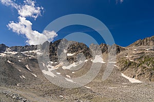 Rocky Mountain Terrain with Snow Patches Under a Clear Blue Sky photo