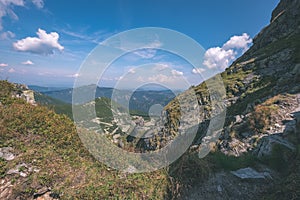 Rocky mountain tops with hiking trails in autumn in Slovakian Tatra western Carpathian with blue sky and late grass on hills.