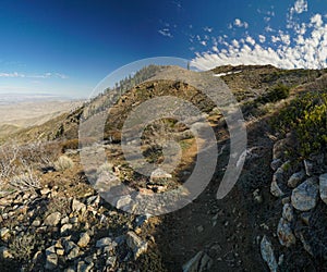 A rocky mountain with a trail leading up to it