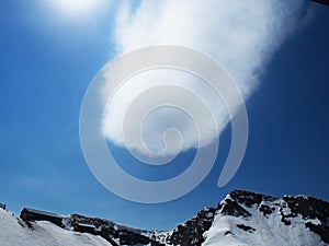 Rocky Mountains ski resort Gorky-gorod. Skiers on the mountain. Cloud trace of metiorite. Russia Sochi