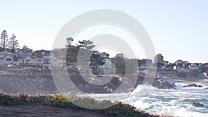 Rocky ocean beach, waves crashing, Monterey, California coast beachfront houses.