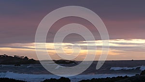 Rocky ocean coast sea waves, Monterey beach California, birds flying, sunset sky