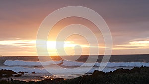 Rocky ocean coast sea waves, Monterey beach California, birds flying, sunset sky