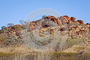 A rocky outcrop of eroded rock rising out of the Australian bush