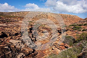 Rocky path in a dry trough of a creek leading to Pot Alley Beach in Kalbarri National Park, Western Australia